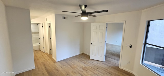 unfurnished bedroom featuring visible vents, multiple windows, baseboards, and light wood-type flooring