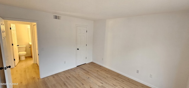 unfurnished bedroom with light wood-style floors, visible vents, a closet, and baseboards