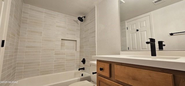 bathroom with visible vents, shower / washtub combination, toilet, a textured wall, and vanity