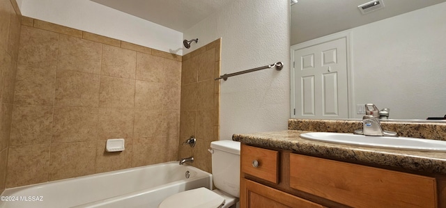 full bathroom with tiled shower / bath combo, vanity, and toilet