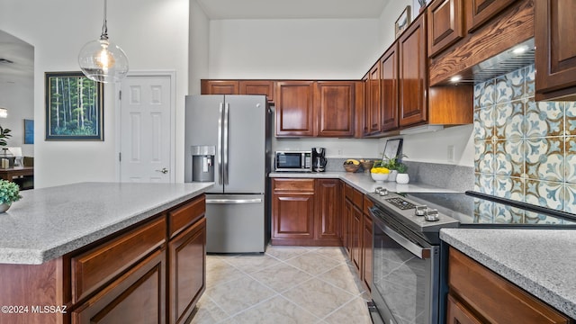 kitchen with appliances with stainless steel finishes, hanging light fixtures, and light tile patterned floors