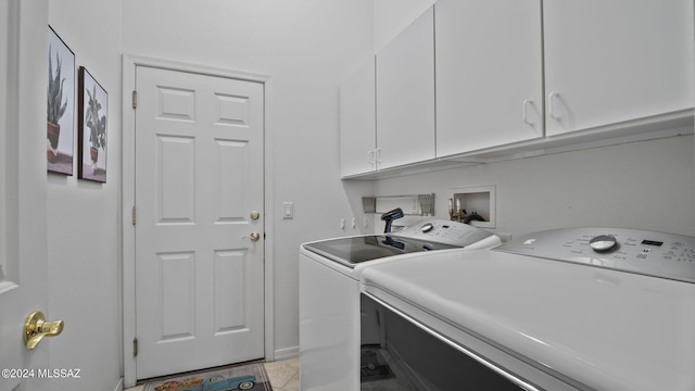 laundry room with washing machine and dryer, light tile patterned floors, and cabinets