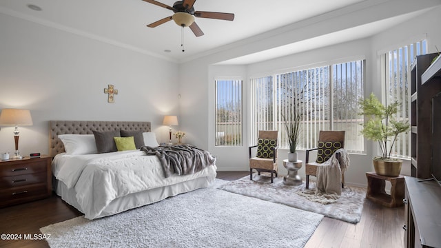 bedroom with ornamental molding, ceiling fan, and dark wood-type flooring