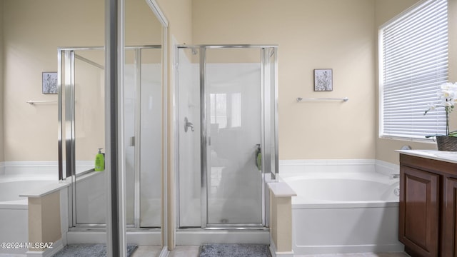 bathroom with independent shower and bath, plenty of natural light, and vanity