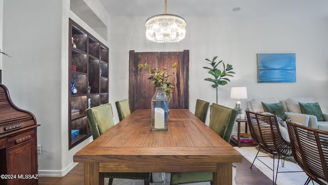 dining area with a notable chandelier and dark hardwood / wood-style flooring