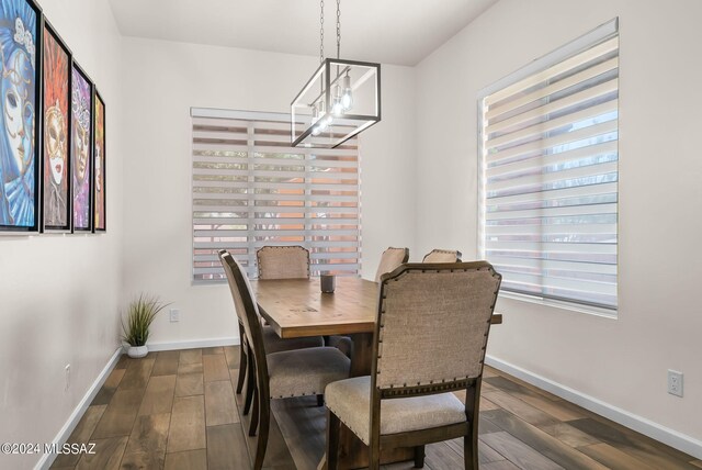 dining space featuring an inviting chandelier, dark hardwood / wood-style flooring, and a wealth of natural light