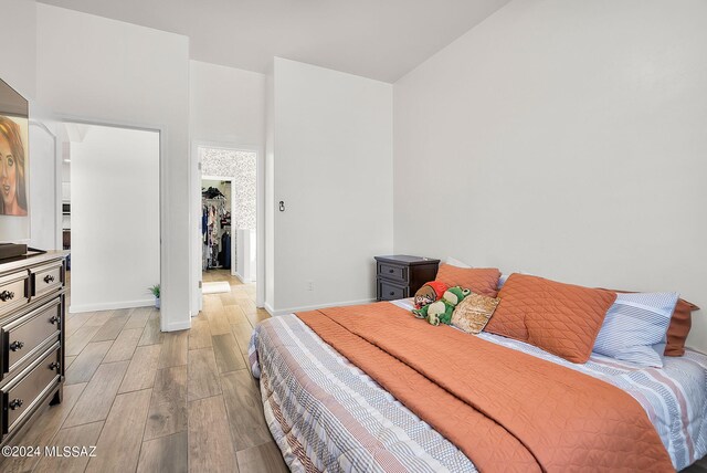 bedroom with light hardwood / wood-style flooring and a closet