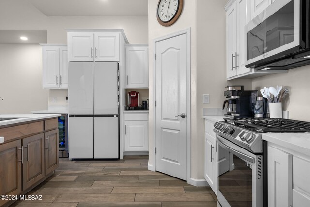 kitchen with white cabinets, appliances with stainless steel finishes, and dark wood-type flooring