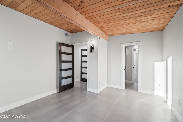 unfurnished room featuring vaulted ceiling with beams and wooden ceiling