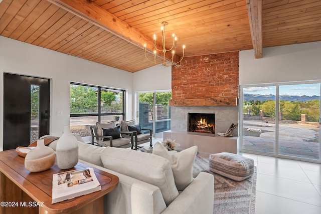 living room with an inviting chandelier, vaulted ceiling with beams, tile patterned floors, a fireplace, and wood ceiling