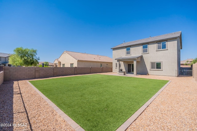 rear view of house featuring a yard and a patio