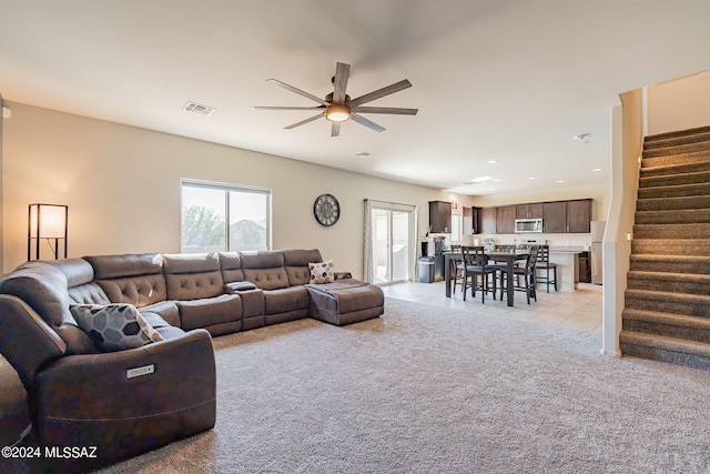 living room featuring light colored carpet and ceiling fan