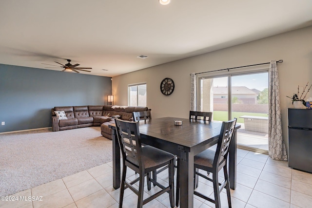 carpeted dining room with ceiling fan