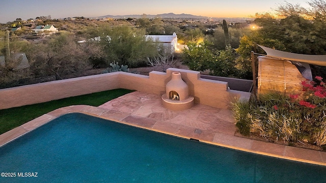 pool at dusk featuring a mountain view