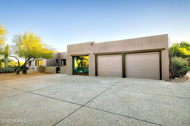 pueblo-style home with a garage