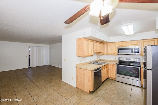 kitchen with appliances with stainless steel finishes, sink, ceiling fan, and light brown cabinets