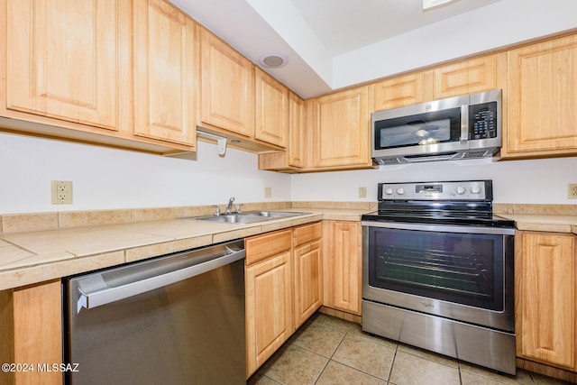 kitchen featuring light brown cabinetry, appliances with stainless steel finishes, and sink