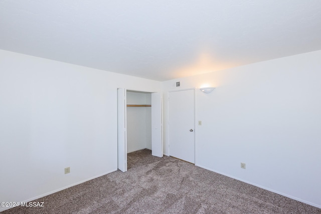 unfurnished bedroom featuring a closet and light colored carpet