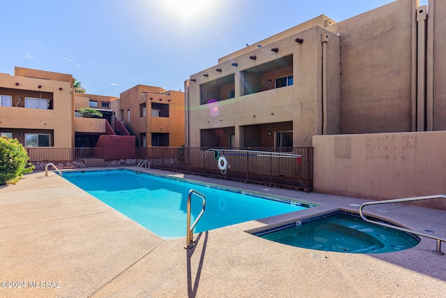 view of swimming pool with a hot tub and a patio area