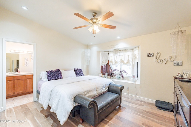 bedroom with light wood-type flooring, ceiling fan, and ensuite bathroom