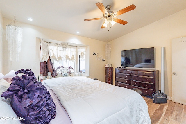 bedroom featuring light hardwood / wood-style flooring, lofted ceiling, and ceiling fan