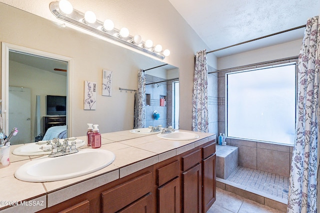 bathroom featuring walk in shower, a healthy amount of sunlight, tile patterned flooring, and vanity