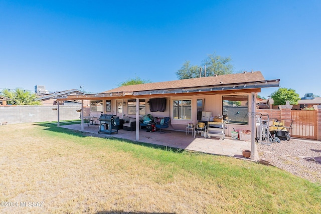 rear view of house featuring an outdoor living space, a lawn, and a patio