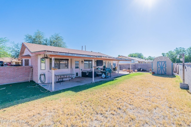 rear view of house with an outdoor hangout area, a patio area, a shed, and a yard