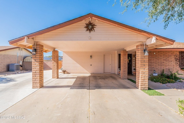 view of front of property featuring central AC and a carport