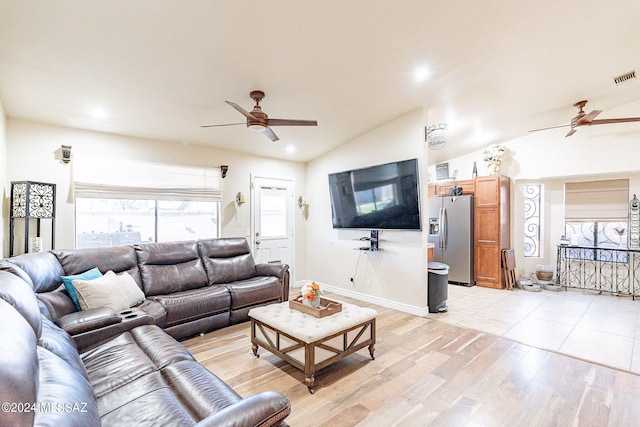 living room with light hardwood / wood-style floors, vaulted ceiling, and ceiling fan