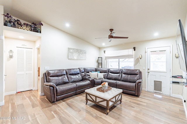 living room featuring light hardwood / wood-style floors, lofted ceiling, and ceiling fan