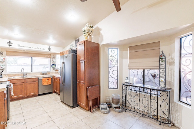 kitchen featuring stainless steel appliances, vaulted ceiling with beams, light tile patterned floors, and sink