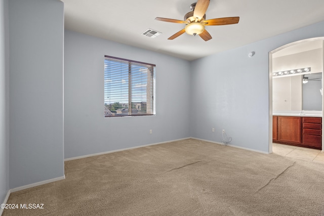 unfurnished bedroom featuring light colored carpet, ceiling fan, sink, and connected bathroom