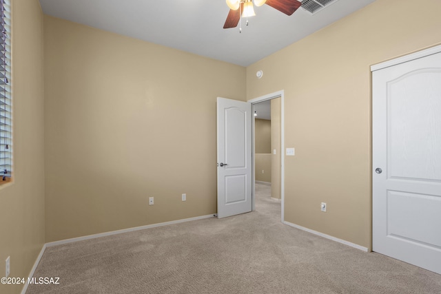 unfurnished bedroom with a closet, light carpet, and ceiling fan