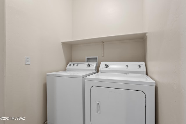 clothes washing area with washer and clothes dryer