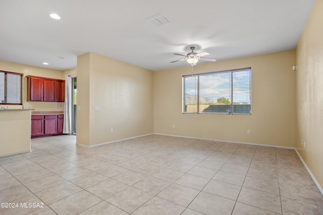 tiled spare room with ceiling fan