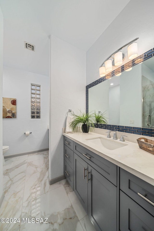 bathroom featuring an enclosed shower, vanity, and toilet