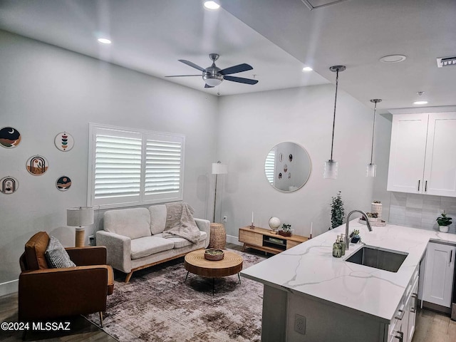 living room with sink, ceiling fan, and light hardwood / wood-style flooring