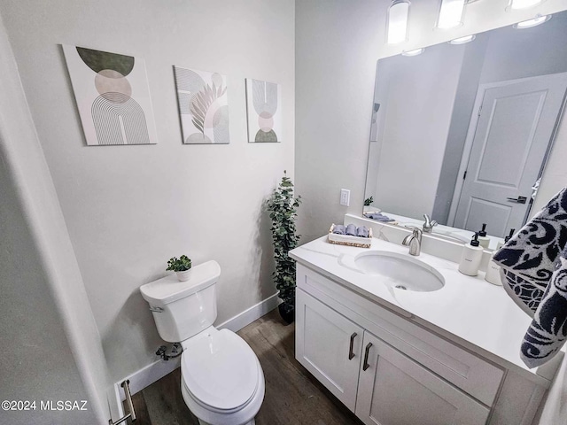 bathroom with wood-type flooring, vanity, and toilet