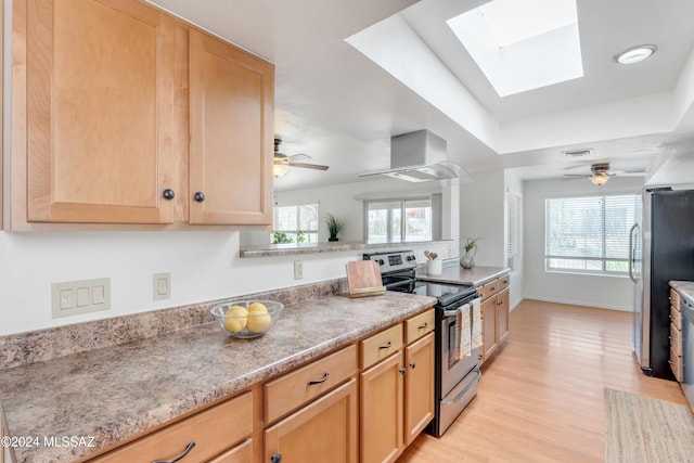 kitchen featuring plenty of natural light, extractor fan, appliances with stainless steel finishes, and light hardwood / wood-style flooring