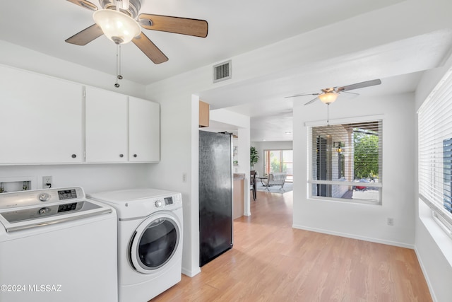 laundry room featuring washer and dryer, light hardwood / wood-style flooring, and cabinets