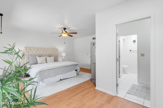 bedroom with ceiling fan, light wood-type flooring, and connected bathroom