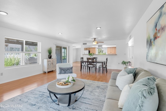 living room with light hardwood / wood-style flooring and ceiling fan