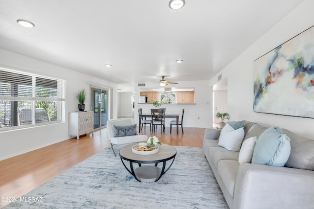 living room featuring light wood-type flooring and ceiling fan