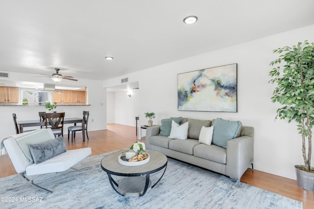 living room featuring light wood-type flooring and ceiling fan