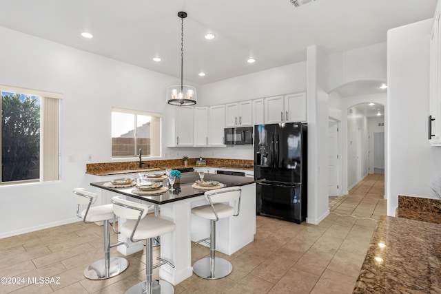 kitchen featuring sink, a breakfast bar area, black appliances, hanging light fixtures, and white cabinets