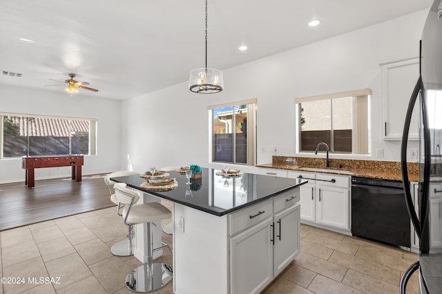 kitchen featuring pendant lighting, dishwasher, sink, white cabinets, and a center island