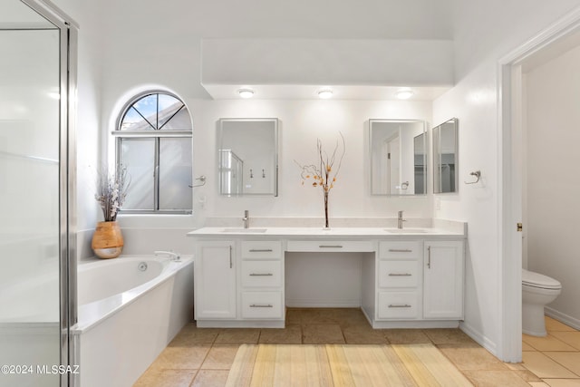 bathroom with vanity, a bath, tile patterned floors, and toilet