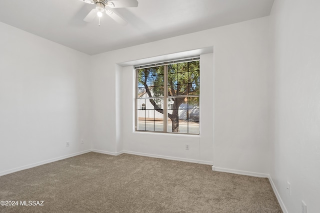 carpeted spare room featuring ceiling fan