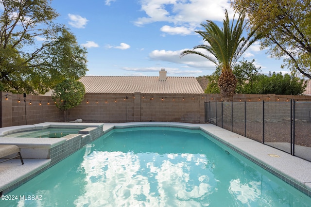 view of swimming pool with an in ground hot tub